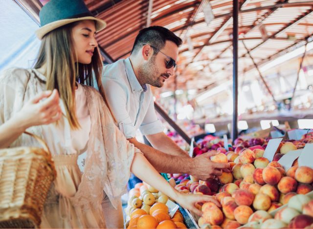 couple picking fruit at farmers market