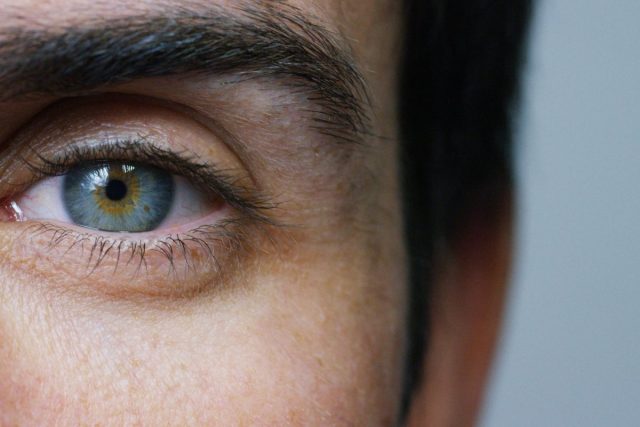 close-up photo of man's blue eye