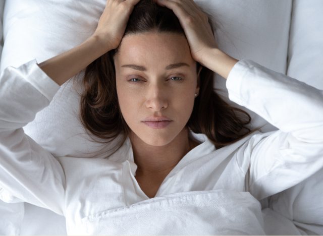 woman annoyed having an unrestful sleep due to bad mattress