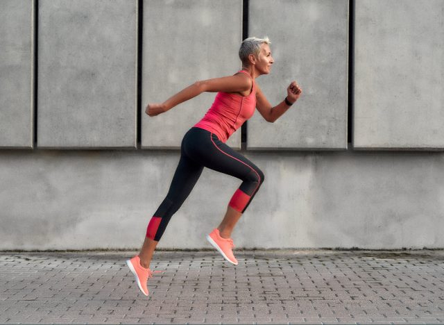 woman in workout attire running on cement