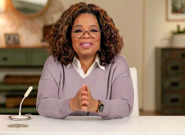 Oprah speaking next to microphone at a desk