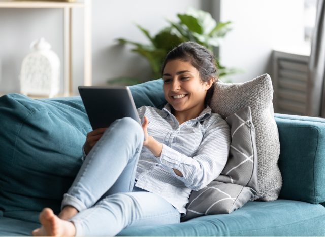 The #1 Virtual Wellness Retreat You Won't Want To Miss — Eat This Not That - Eat This, Not That 6 woman relaxed and happy on couch while viewing virtual event on tablet