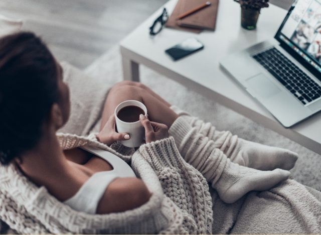 woman cozy on couch tunes into virtual event