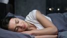 woman sleeps peacefully in plush gray bedding