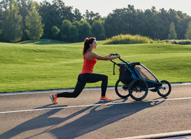 woman in workout attire doing stroller lunges