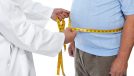 Doctor measuring obese man waist body fat.