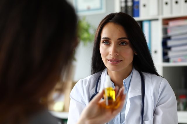 Female GP giving medical marijuana oil to patient.
