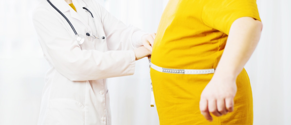 Doctor measures a patient's waist.