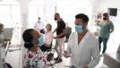 Patient arriving at medical clinic and being called by the doctor using face mask.