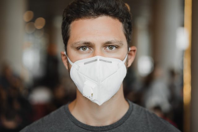 A man in respirator mask at the airport.