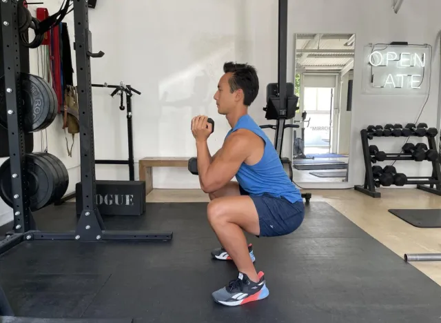 trainer does goblet squat exercise to get rid of flabby stomach