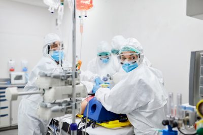 Healthcare workers operating on patient in ICU