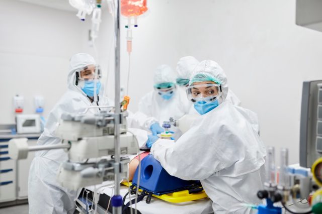 Healthcare professionals operating on a patient in the intensive care unit