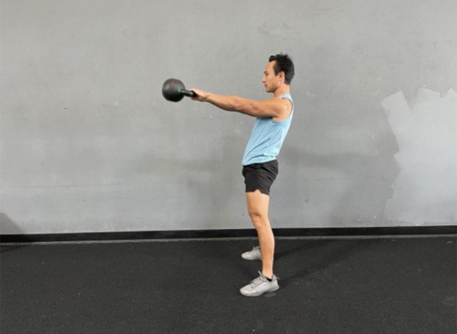 trainer swinging with kettlebells