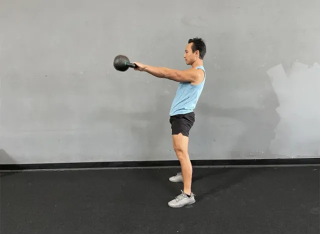 trainer doing kettlebell swing