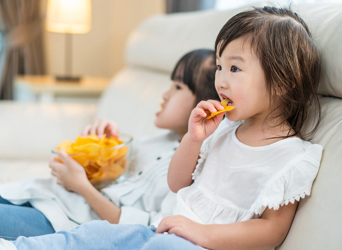 kids eating chips on a couch