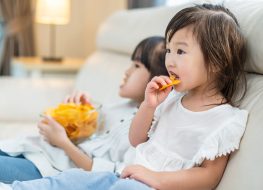kids eating chips on a couch