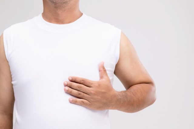 A man in posture of care or protect himself from breast cancer.