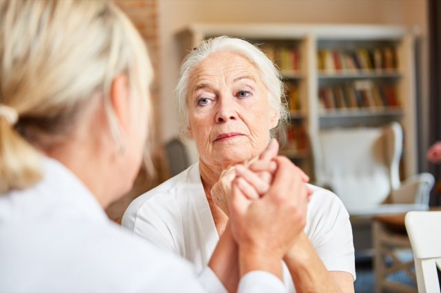 Elderly woman in consultation with a doctor or therapist