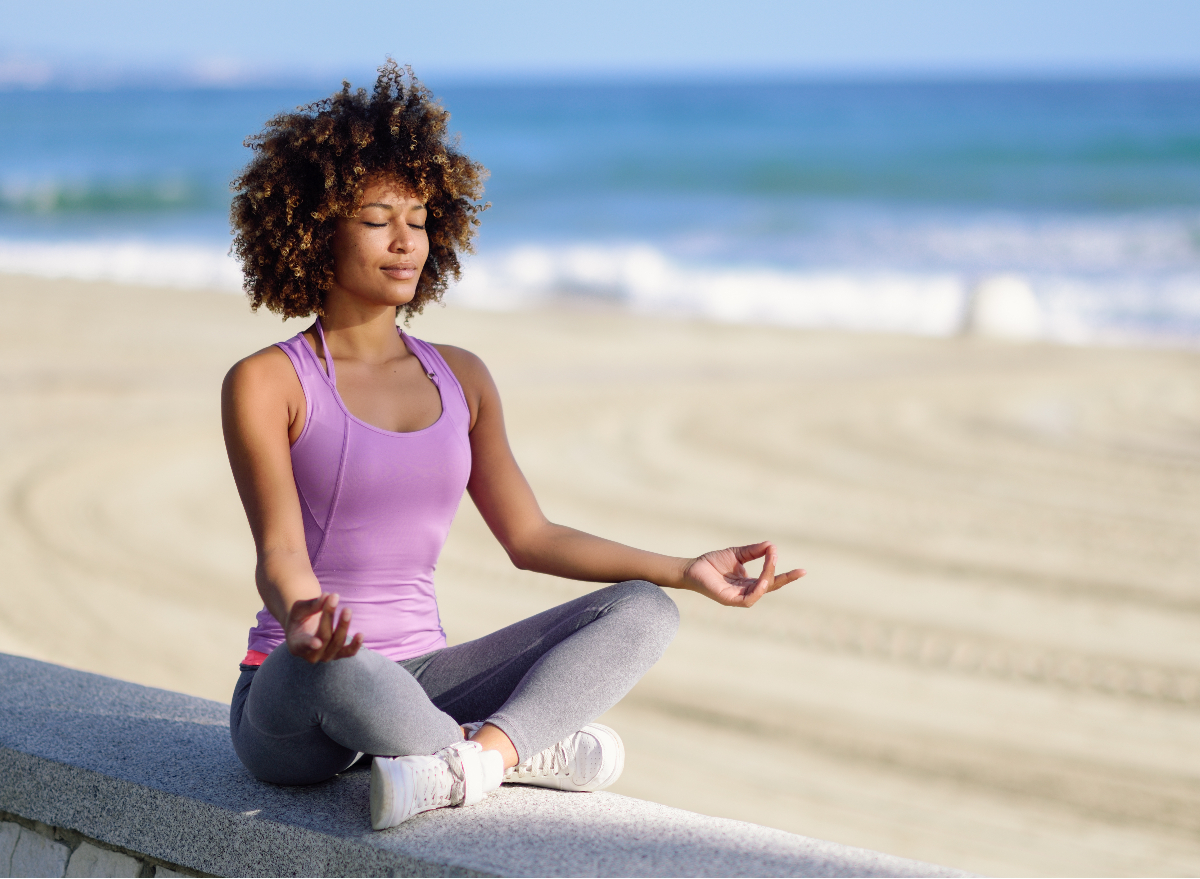 woman meditating on the beach