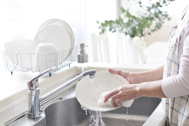 Woman washing dishes.