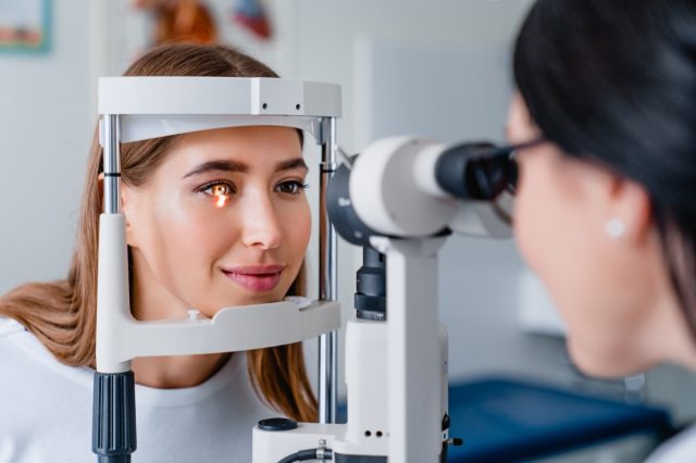 Eye doctor with female patient during an examination in modern clinic.