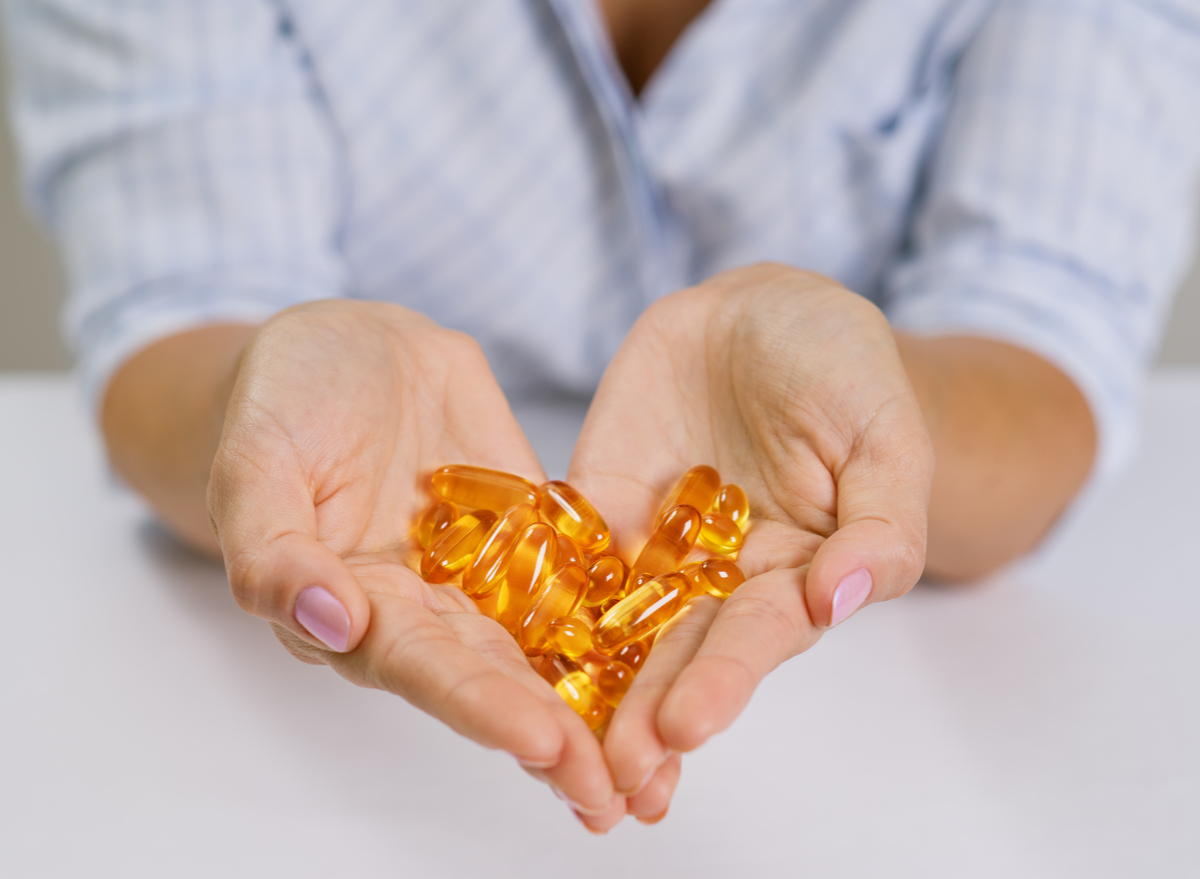 woman holding omega-3 capsules