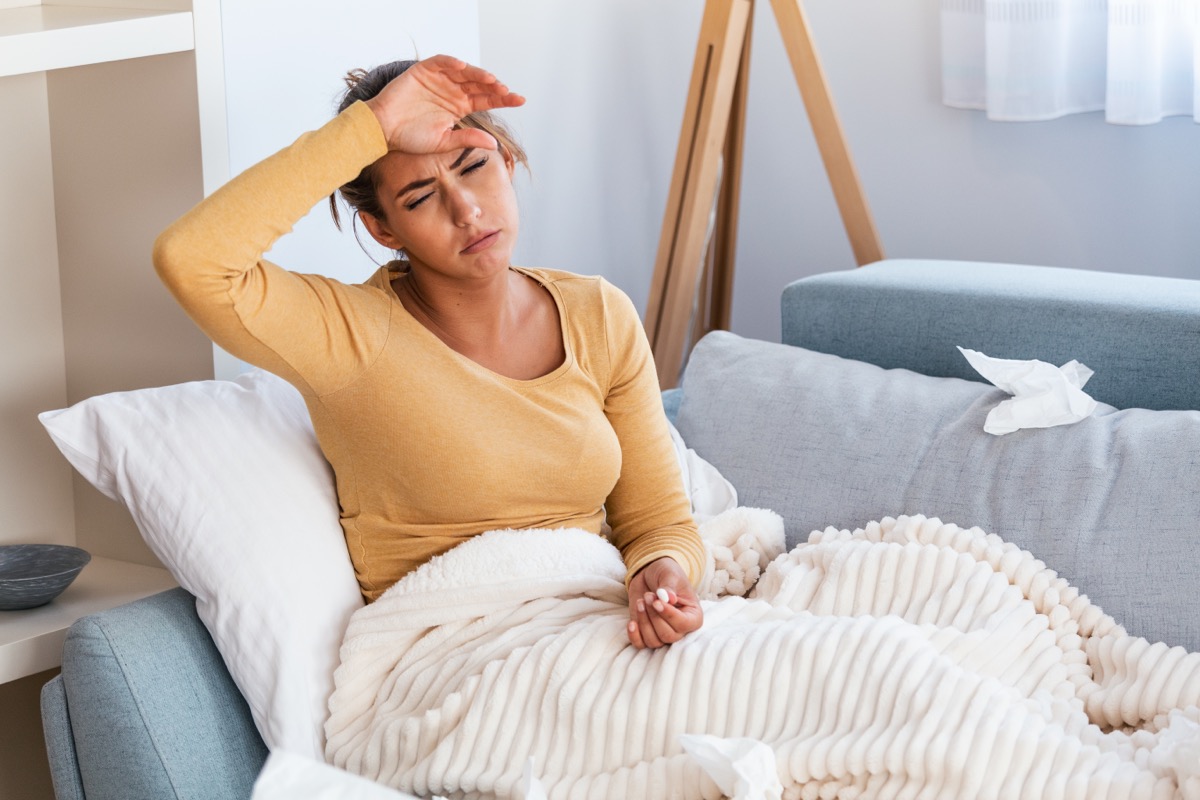 Young sick woman laying in her bed.