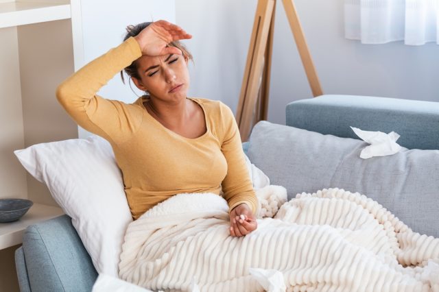 Young sick woman laying in her bed.