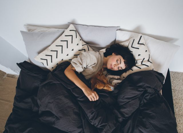 woman sleeping with her dog