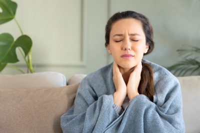 Young woman touching painful neck, sore throat for flu, cold and infection.