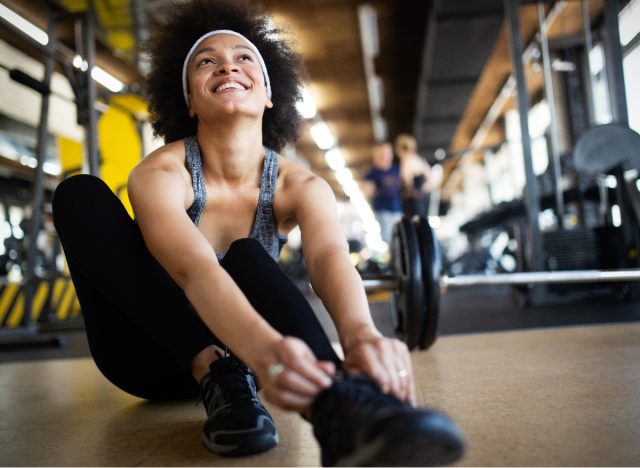 woman tying sneakers at gym