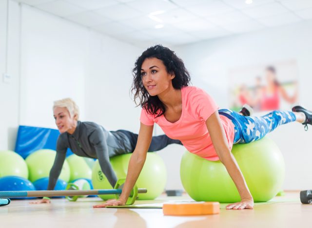 woman balances on stability ball in workout class