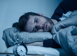 man stressed in bed that he can't sleep