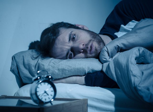 man stressed in bed that he can't sleep