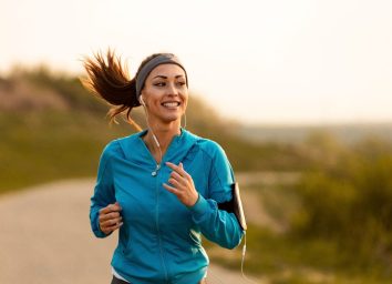 happy woman jogs along trail