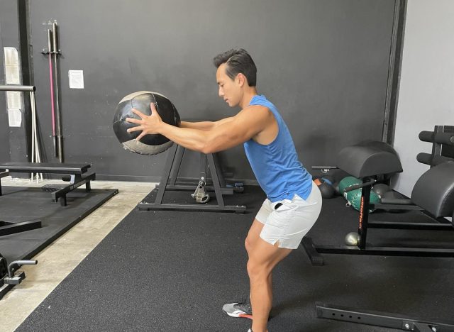 trainer does squat with medicine ball