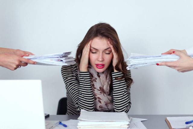 woman puts hands on head, stressed, busy at work