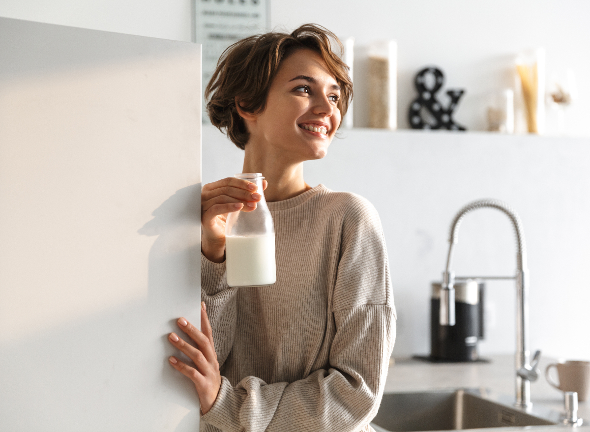 woman holding jug of milk she took out of the fridge