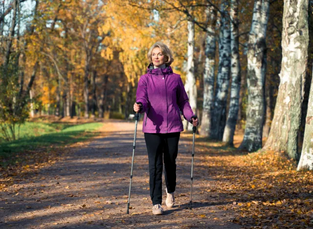 senior woman on fall hike with walking poles