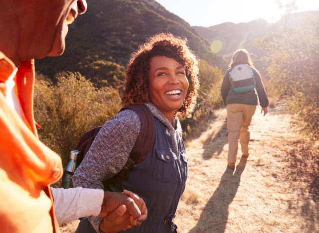 happy woman hikes up mountain with SO