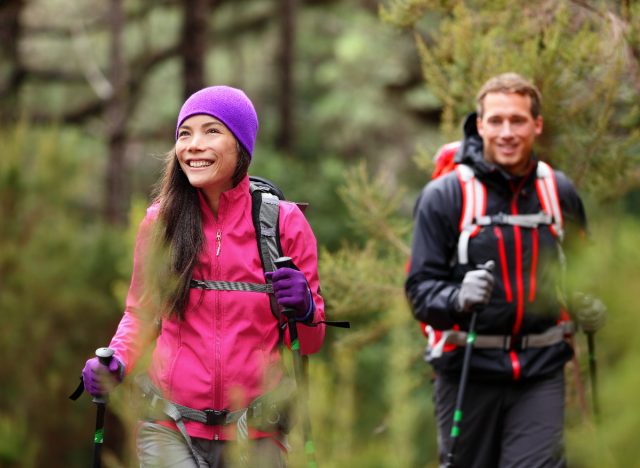happy couple hikes in nature to burn fat and get active