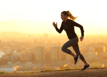 serious woman running at sunset