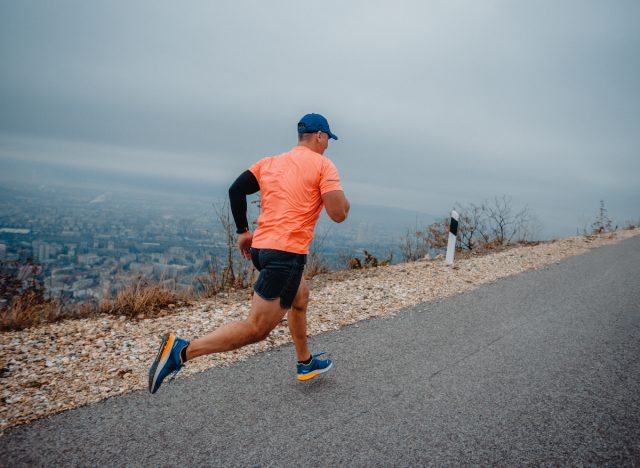 man running with city in background, doing cardio only representing bad fitness habits