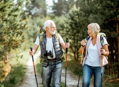 senior couple hiking with walking sticks