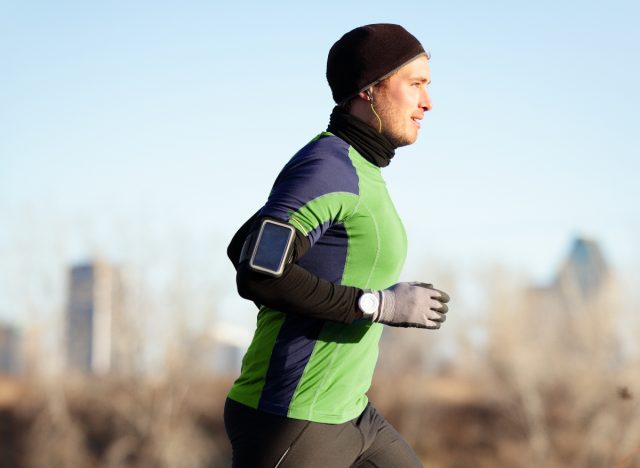 athletic man running outside city