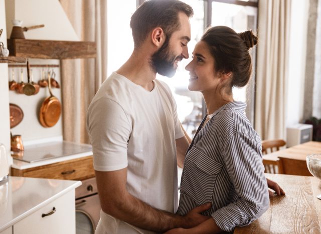 happy couple embraces in bright kitchen