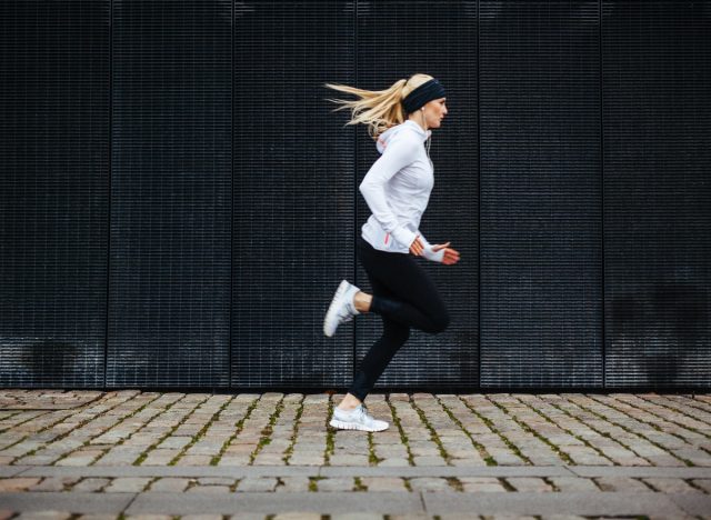 athletic woman runs outdoors in city