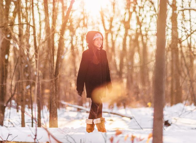 woman walking through snowy woods