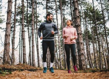 happy couple exercising in the woods
